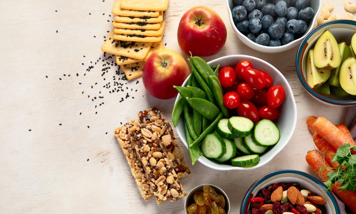 Selezione di alimenti vegetali ricchi di fibre con frutta, verdura, semi e frutta secca